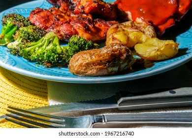 Plate Of BBQ And Grilled Food Including Smashed Potatoes Memphis Rubbed Chicken Thighs Charred Broccoli And Saucy Ribs