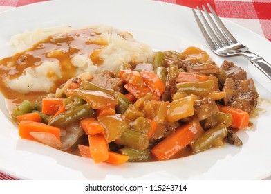 A Plate Of Beef Pot Roast With Mashed Potatoes And Gravy