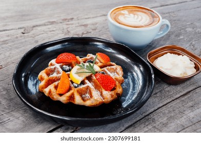 Plate of belgian waffles with ice cream, caramel sauce and fresh strawberry - Powered by Shutterstock