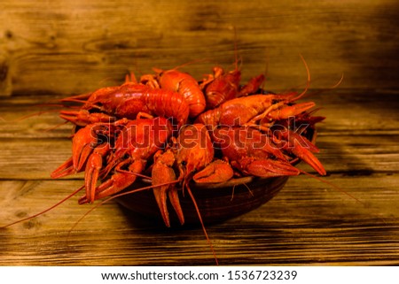 Plate with boiled crayfishes on rustic wooden table