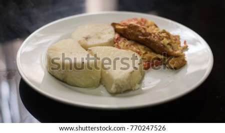 A plate of boiled yam and eggs fried with tomato and pepper