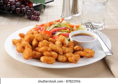 A Plate Of Breaded Popcorn Shrimp With A Salad