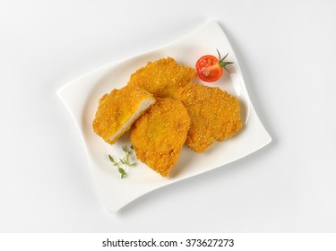 plate of breaded turkey breasts on white background