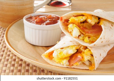 A plate of breakfast burritos and black coffee