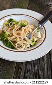 Plate broccoli and Alfredo sauce. Background from old boards