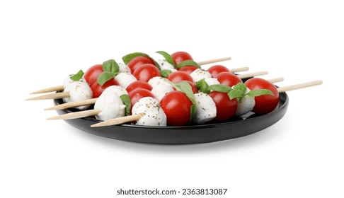 Placas de brochetas capresas con tomates, bolas de mozzarella, albahaca y especias aisladas en blanco