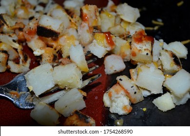 A Plate Of Cheesy Ketchup Hash Browns Closeup View