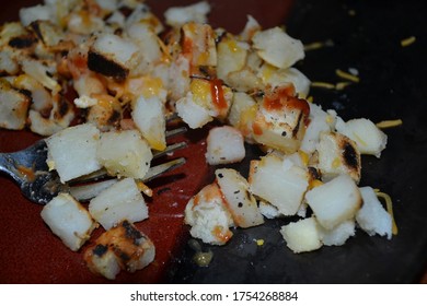 A Plate Of Cheesy Ketchup Hash Browns Closeup View