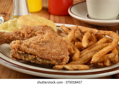 A Plate Of Chicken And Biscuits With French Fries Close Up