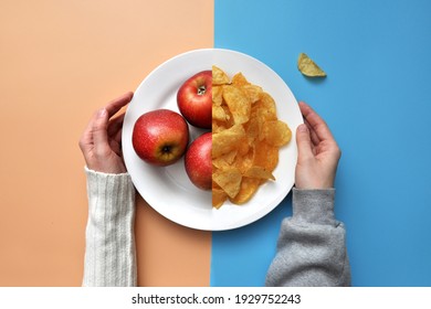 a plate of chips and red apples. A person chooses between healthy and unhealthy food - Shutterstock ID 1929752243