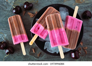 Plate Of Chocolate And Cherry Ice Pops. Close Up Above View Table Scene On A Dark Stone Background.