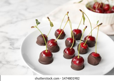 Plate of chocolate dipped cherries on white marble table - Powered by Shutterstock