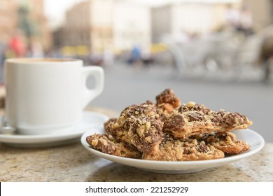 A Plate Of Chocolate Toffee Nut Cookies And A Cappuccino At An Outdoor European Cafe.