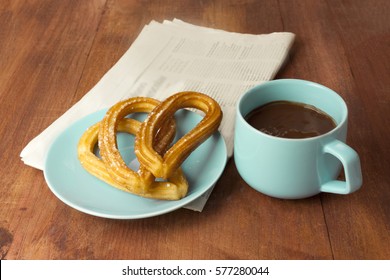 Plate Of Churros, Traditional Spanish, Especially Madrid, Dessert, Particularly For Sunday Breakfast, With Cup Of Hot Chocolate And Blurred Newspaper