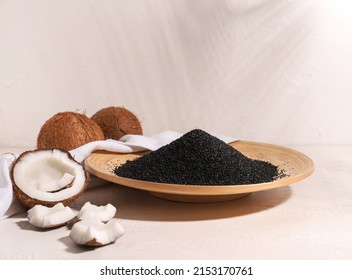 Plate with coconut activated carbon on white background