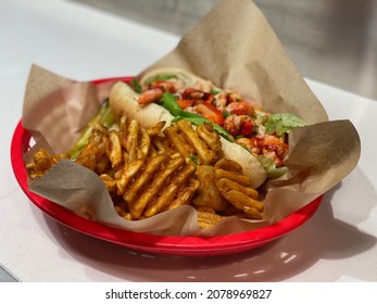 A Plate Of Connecticut Style Lobster Roll With Cajun Fries