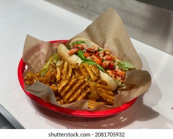 A Plate Of Connecticut Style Lobster Roll With Cajun Fries