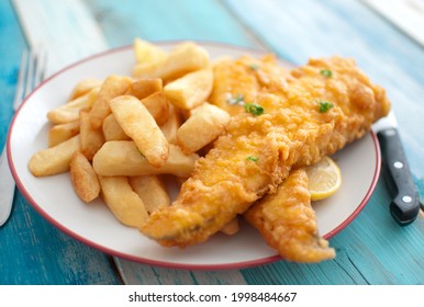 Plate Of Deep Fried Cod In Batter With Portion Of Chunky Chips