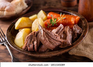 A Plate Of Delicious Beef Pot Roast With Potatoes And Carrots With Thyme Garnish.