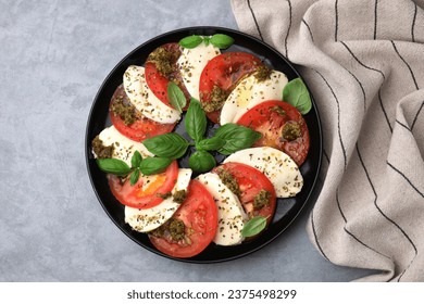 Plate of delicious Caprese salad with pesto sauce on grey table, top view - Powered by Shutterstock