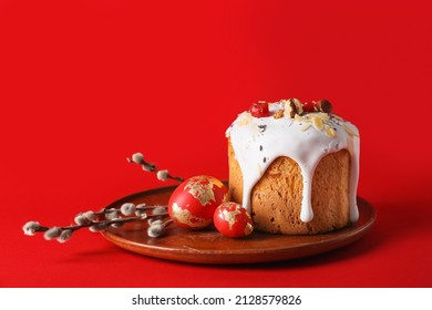 Plate with delicious Easter cake, eggs and pussy willow branches on red background