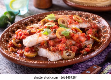 A Plate Of Delicious Fish Veracruz With Olives, Tomato, Onion, Capers And Serrano Pepper.