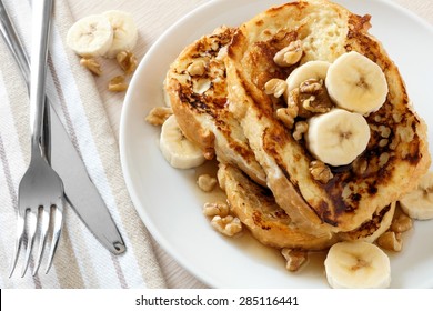 Plate Of Delicious French Toast With Bananas, Walnuts And Dripping Maple Syrup, Overhead View       