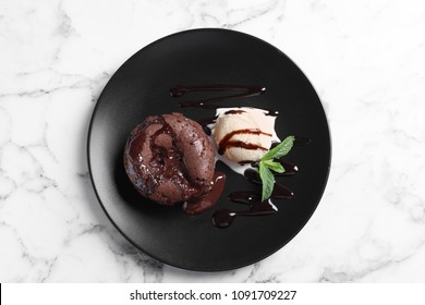 Plate of delicious fresh fondant with hot chocolate and ice cream on table, top view. Lava cake recipe