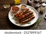 Plate with delicious grilled thin sausages on brown wooden background. Close up view