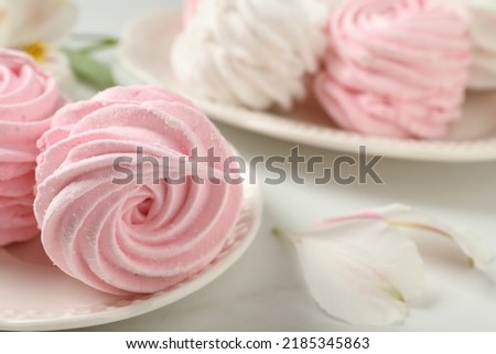 Plate with delicious pink zephyrs on white table, closeup. Space for text