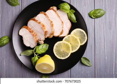 Plate With Delicious Sliced Turkey Fillet And Lemon On Table