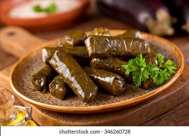 A plate of delicious stuffed grape leaves with parsley garnish.