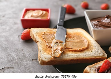 Plate With Delicious Toast And Peanut Butter On Table, Closeup