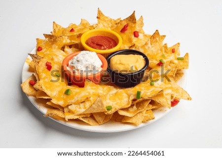 A plate of delicious tortilla nachos with melted cheese sauce and dressing