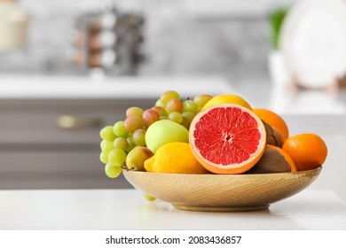 Plate with different fruits on kitchen table - Shutterstock ID 2083436857