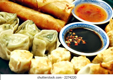 Plate Of Dim Sum, Egg Rolls, Shumai, And Pot Stickers With Dipping Sauce