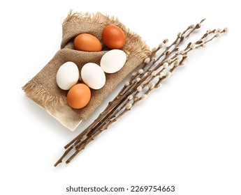 Plate with Easter eggs and willow branches on white background