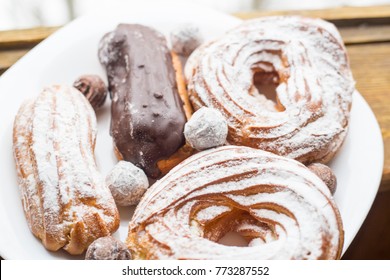 A Plate With Eclairs And Curd Rings