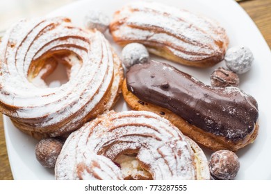 A Plate With Eclairs And Curd Rings