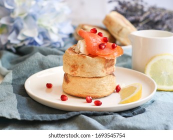 A Plate Of English Muffin Topped With Smoke Salmon And Lemon Sliced With A Pomegranate Fruit Dish Decoration 