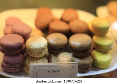 A plate filled with macarons, with the two to the the front left showing more prominently