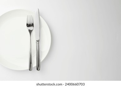 Plate, fork and knife on white background, top view. Space for text - Powered by Shutterstock