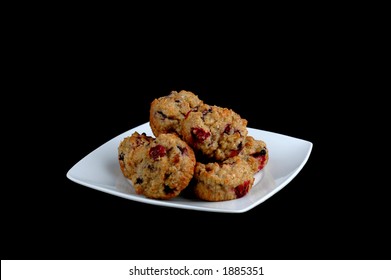 Plate Of Fresh Baked Blueberry Cranberry Muffins Isolated On A Black Background