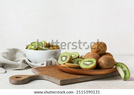 Plate with fresh cut kiwi on light background