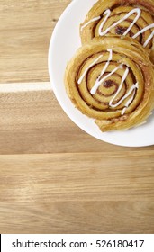 A Plate Of Freshly Baked Cinnamon Swirls On A Wooden Kitchen Counter Background With Empty Space Below