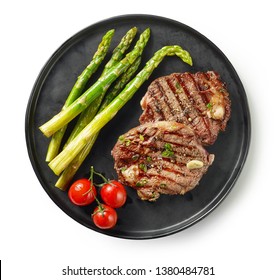 plate of freshly grilled juicy beef steak meat with thyme and asparagus isolated on white background, top view