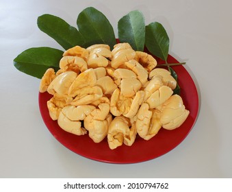 A plate of freshly picked Jamaican ackee with some ackee leaf in the background