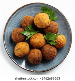 plate of fried falafel balls and parsley leaves isolated on white background top view