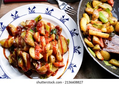 A Plate Of Fried Potatoes With Curry Ketchup.