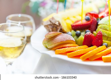 Plate with fruit and glass of champagne close-up